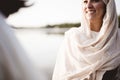 Shallow focus shot of a female wearing a biblical robe while talking to Jesus Christ Royalty Free Stock Photo