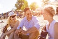 Shallow focus shot of a group of Caucasian friends having fun on a sandy beach