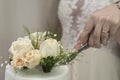 Shallow focus shot of the hands of a married couple cutting the wedding cake with white flowers Royalty Free Stock Photo