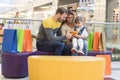 Shallow focus shot of a happy Caucasian family sitting in a mall playing with a stuffed animal