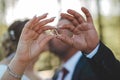 Shallow focus shot of newlyweds hands showing their wedding rings while kissing during their wedding Royalty Free Stock Photo