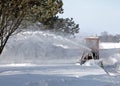 Shallow focus shot of a snow thrower machine removing snow in the ground during winter