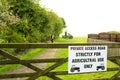 Shallow focus of a sign and wooden gate warning of private access to a farm field. Royalty Free Stock Photo