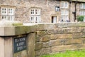 Shallow focus of a slate made Tea Room and Village shop sign attached to a stone wall.