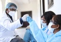 Shallow focus of South Asian health workers in protective suits doing a fist bump Royalty Free Stock Photo