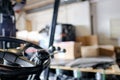 Shallow focus of the steering wheel and knob seen on a warehouse forklift truck.