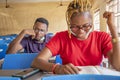 Shallow focus of two young African students wearing facemasks and studying in a classroom Royalty Free Stock Photo