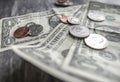 Close-up of used American banknotes and coinage seen on a wooden desk.