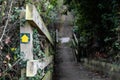 Shallow focus of a yellow footpath direction sign seen attached to a wooden bannister Royalty Free Stock Photo