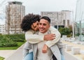 Shallow focus of a young smiling man carrying his girlfriend on his back Royalty Free Stock Photo