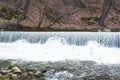 A shallow river, fast and bubbling, a low waterfall, in a castle park Royalty Free Stock Photo