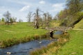 Shallow River Flowing Under a Small Stone Bridge. Royalty Free Stock Photo