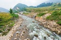 Shallow rock river in Sa Pa, Vietnam surrounded by rice terraces