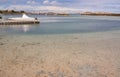 Shallow water in the bay, a pier on the fjord, moored boat Royalty Free Stock Photo