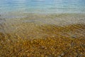 Shallow water of Lake Constance with round stones on the bottom. Royalty Free Stock Photo