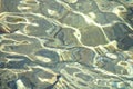 Shallow water over gravel bottom with reflections and small waves Royalty Free Stock Photo
