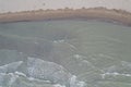 Shallow water of sea on the sandy beach with muddy water in Karpen, Albania, Europe