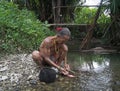 Shaman cleaning chicken viscera in a river Royalty Free Stock Photo