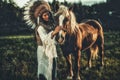 Shaman woman in landscape with her horse.