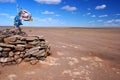 Ovoo, oboo or obo ceremonial rock pile with sacred hadags or khadags blue silk scarves and prayer flag, Gobi Desert Mongolia