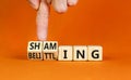 Shaming and belittling symbol. Concept words Shaming and Belittling on wooden cubes. Businessman hand. Beautiful orange table Royalty Free Stock Photo