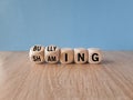Shaming and bullying symbol. Concept words Shaming and Bullying on wooden cubes. Beautiful wooden table, blue background. Business