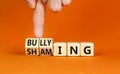 Shaming and bullying symbol. Concept words Shaming and Bullying on wooden cubes. Businessman hand. Beautiful orange table orange Royalty Free Stock Photo