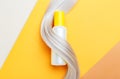 Shampoo bottle mockup strand in lock curl of blonde hair on orange color background. Yellow bottle shampoo. Flat lay copy space.