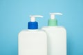 Shampoo or hair conditioner bottles with dispenser pump on blue background. Royalty Free Stock Photo