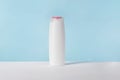Shampoo white cosmetic bottle mockup on blue background. Hair product, bath soap or lotion packaging. Plastic cosmetics Royalty Free Stock Photo