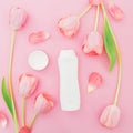 Shampoo and white tulips flowers on pink background. Flat lay, top view Royalty Free Stock Photo