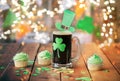 Shamrock on beer glass, green cupcakes and coins Royalty Free Stock Photo