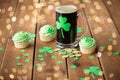 Shamrock on glass of beer, green cupcake and coins Royalty Free Stock Photo