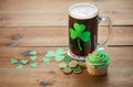 Shamrock on glass of beer, green cupcake and coins Royalty Free Stock Photo