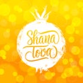 Shana Tova hand lettering with brush stroke pomegranate and honey bokeh background. Jewish New Year Rosh Hashanah greeting card. Royalty Free Stock Photo