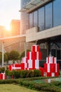 A pile of red big gift boxes in front of modern architecture