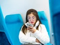 SHANGHAI, CHINA 13 MARCH 2019 - A young Chinese woman uses an Apple iphone on the Maglev train heading to Pudong International