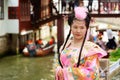 Shanghai, China - May, 2019: Chinese beautiful asian woman in national dress against Shanghai Zhujiajiao ancient Town in Shanghai