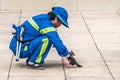 Blue clad worker removes gum from surface, Shanghai, China