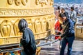 Chinese tourist man spinning the Giant Tibetan Buddhist prayer wheel of Dafo temple in Dukezong old town in Shangri-La Yunnan Royalty Free Stock Photo