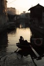 SHAOXING, CHINA: Silhouette of a man sitting on wupeng boat black-awning boat