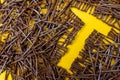 The shape of a hammer between rusty nails. Yellow background. From above Royalty Free Stock Photo