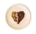 Shape heart of coffee beans and peeled walnuts on the plate, Val