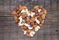 Shape of heart made from almonds, cashews and hazelnuts on a rustic wooden background. Top view. Healthy concept