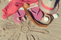 Shape of sun and different accessories for relax on sand. Straw hat, slippers and towel. Summer time on beach