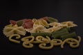 Shaped and colorful pasta in different sizes and colors  in small dishes together at close range. Royalty Free Stock Photo