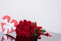 Shaped heart gift box and bouquet red classic roses on a mirror surface. Festive floristry. Gift to a woman. Sample