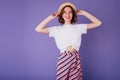 Shapely lady in white t-shirt and vintage hat posing in studio with smile. Indoor photo of glad eur Royalty Free Stock Photo