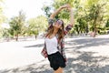 Shapely pretty woman laughing on nature background. Refined girl in glasses dancing in park.