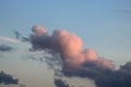 Shapes of clouds tinged pink by approaching sunset